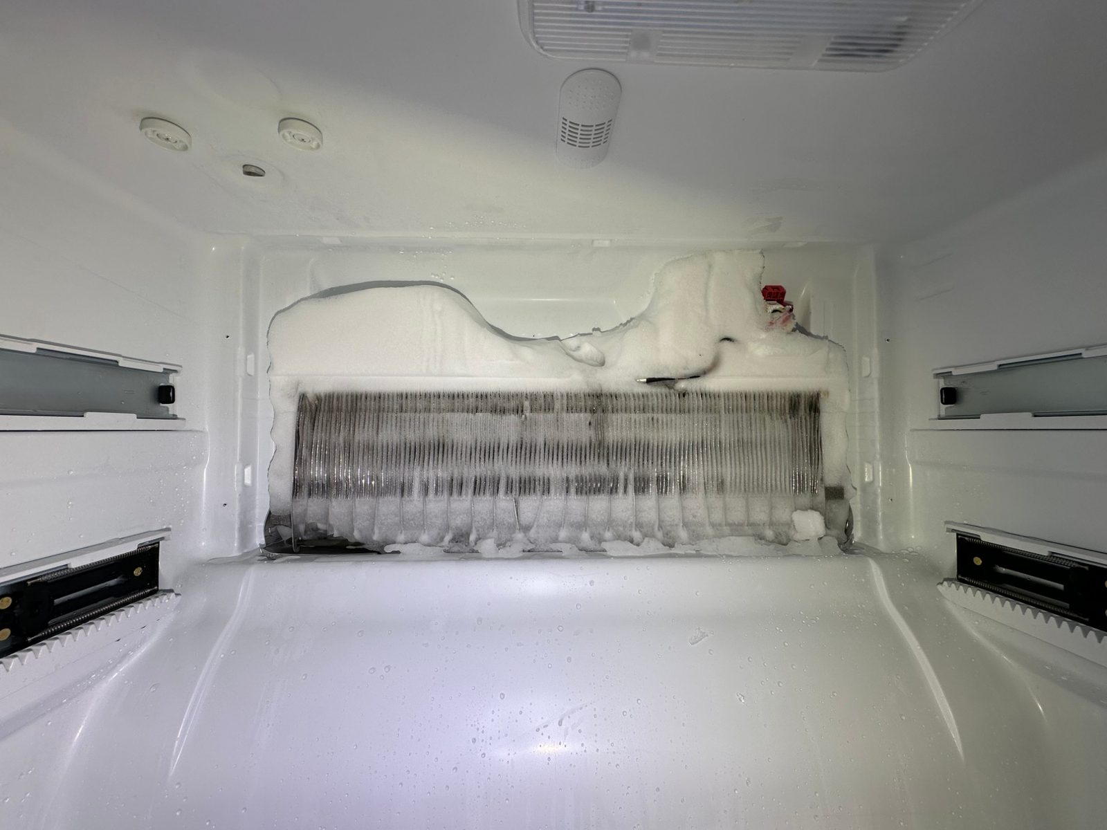 Bosch freezer with the back panel removed, the evaporator coil packed with ice and frost