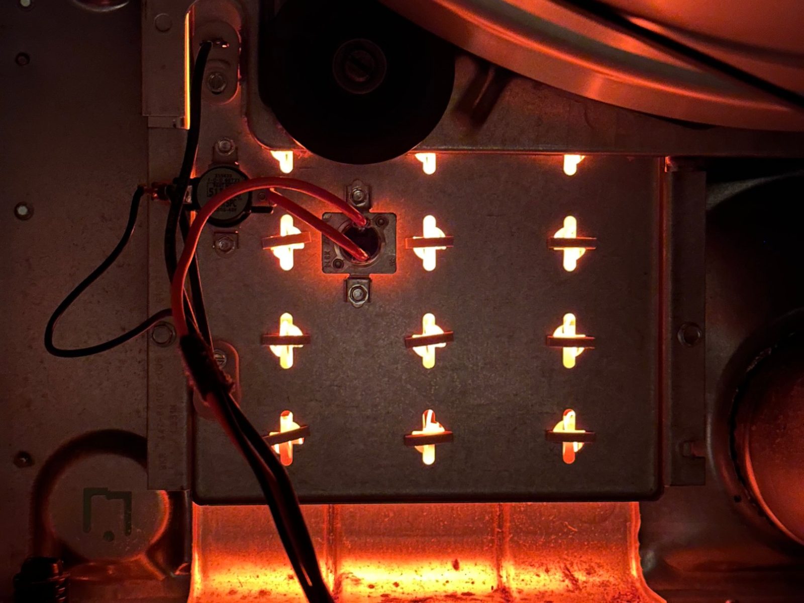 New heating element glowing through the heater housing of a Speed Queen dryer in Kenmore during the post-repair test