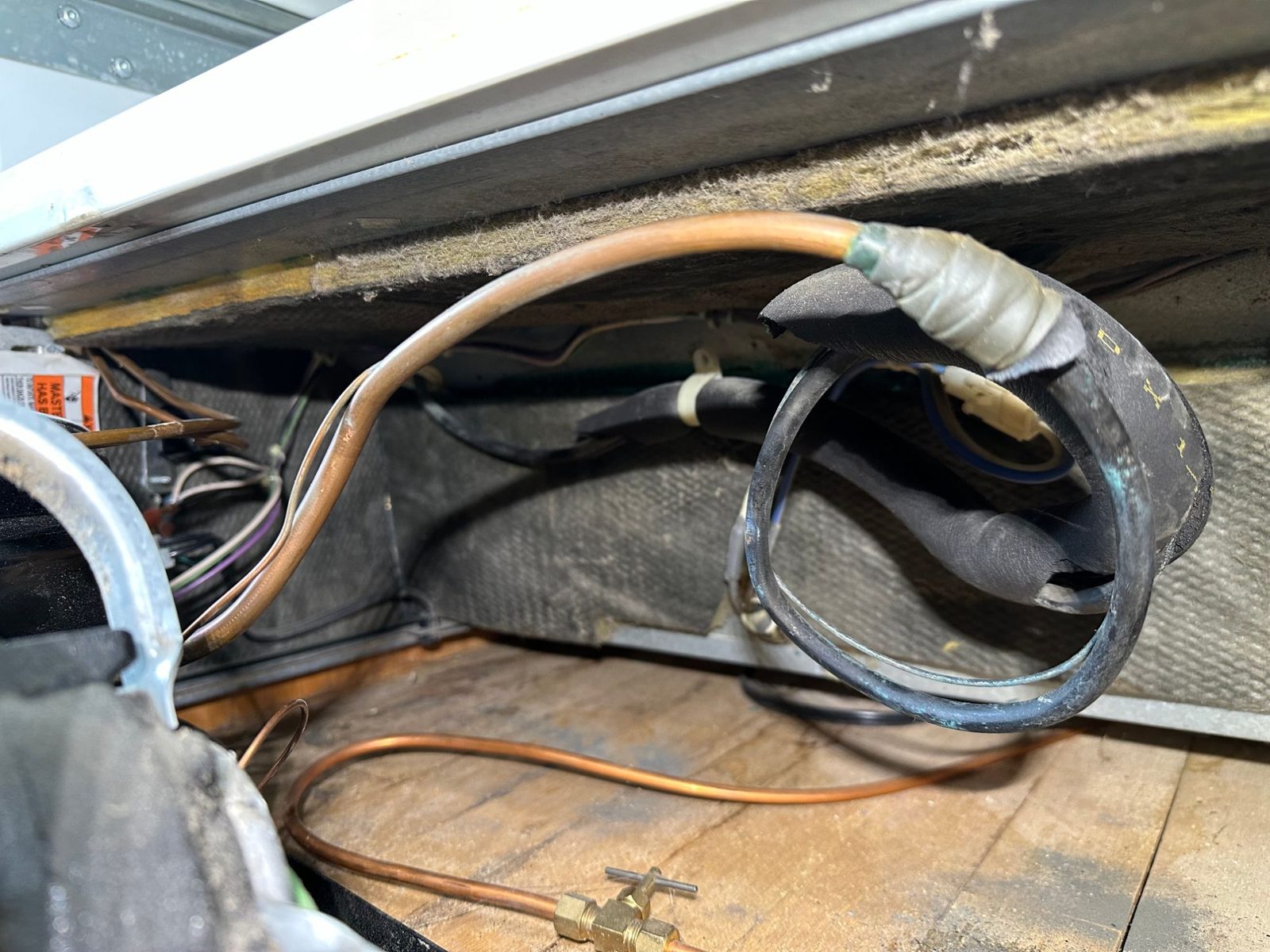 Corroded copper heat exchanger loop under the Sub-Zero 700BFI freezer, where the refrigerant leak was found