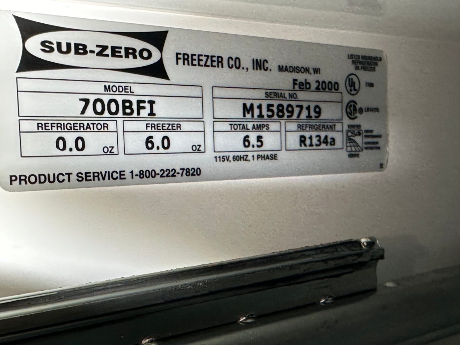 Sub-Zero nameplate inside the freezer showing model 700BFI, manufactured February 2000, R134a refrigerant, 6.0 oz freezer charge