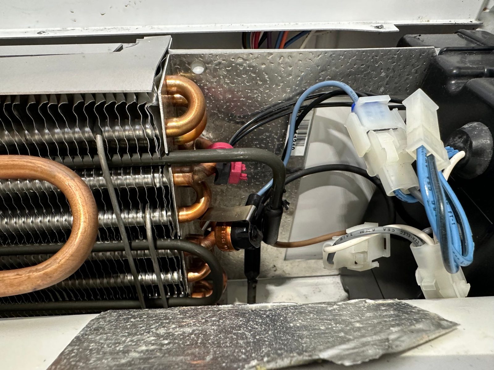 New evaporator coil installed in the Sub-Zero freezer with defrost heater and control wiring connectors reattached