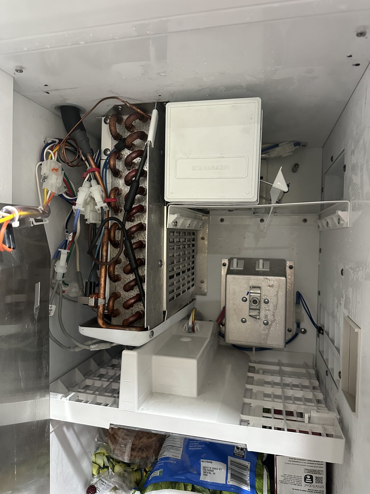 Sub-Zero ice maker repair, freezer compartment open showing evaporator coils and ice maker unit
