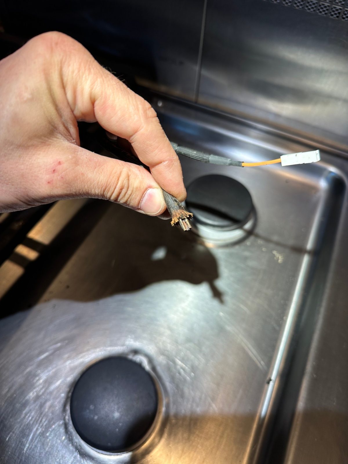 End of an old Wolf igniter lead with corroded strands where it meets the burner