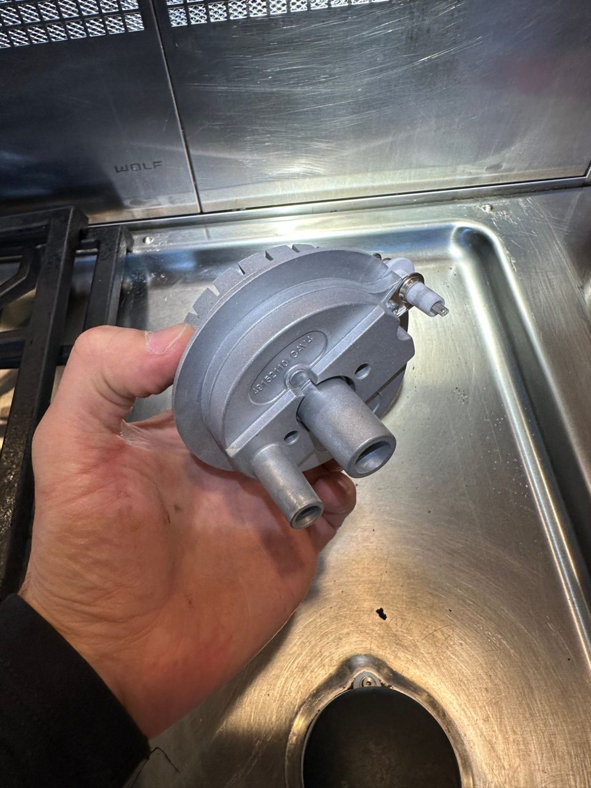 Underside of the new Wolf burner showing gas inlets and the new spark electrode built into the assembly