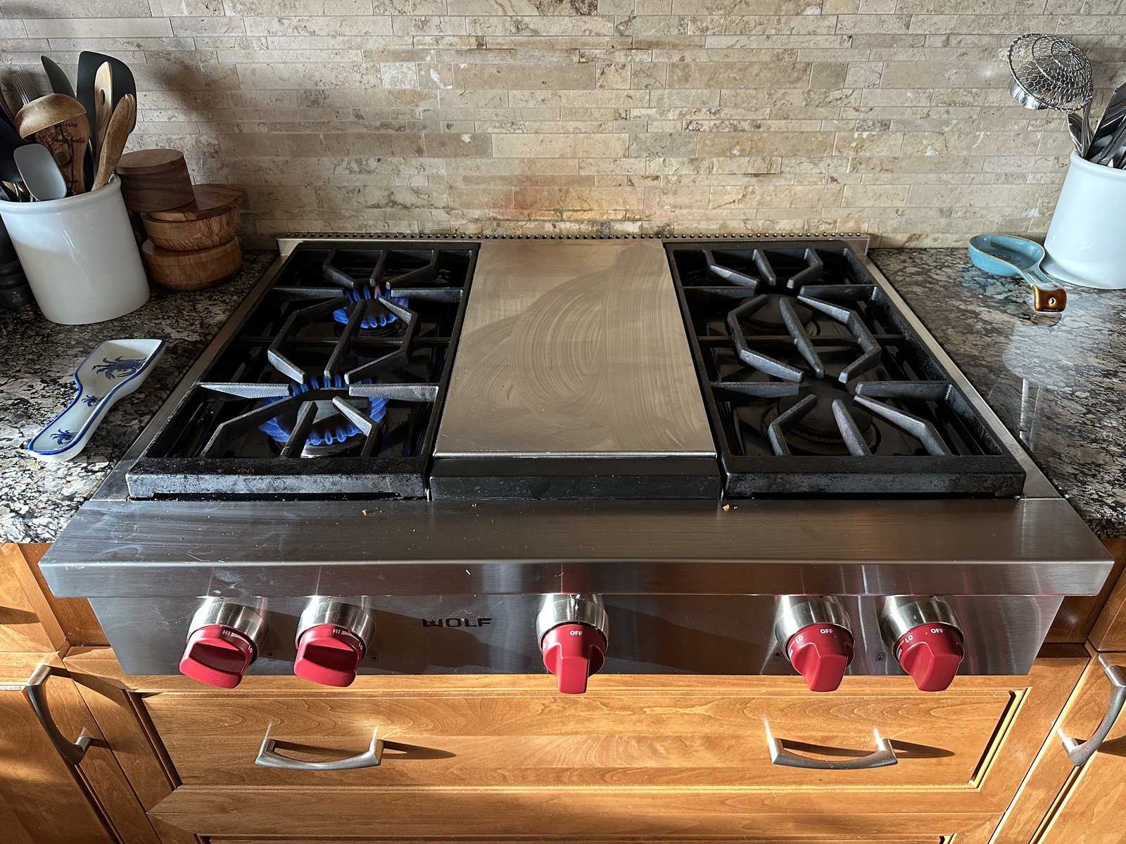 Wolf gas rangetop reassembled with burners lit and functioning after spark module replacement