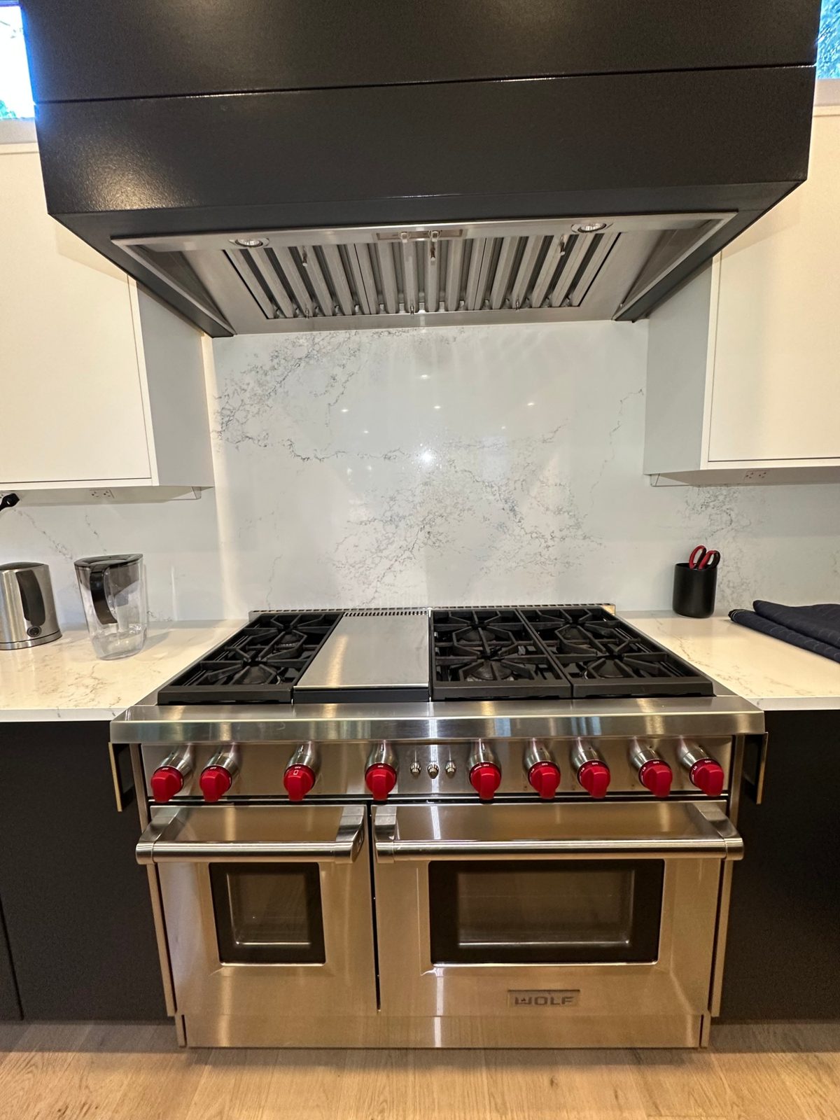 Wolf GR486G gas range fully reassembled with all grates back on under the range hood after the spark module repair in Kirkland